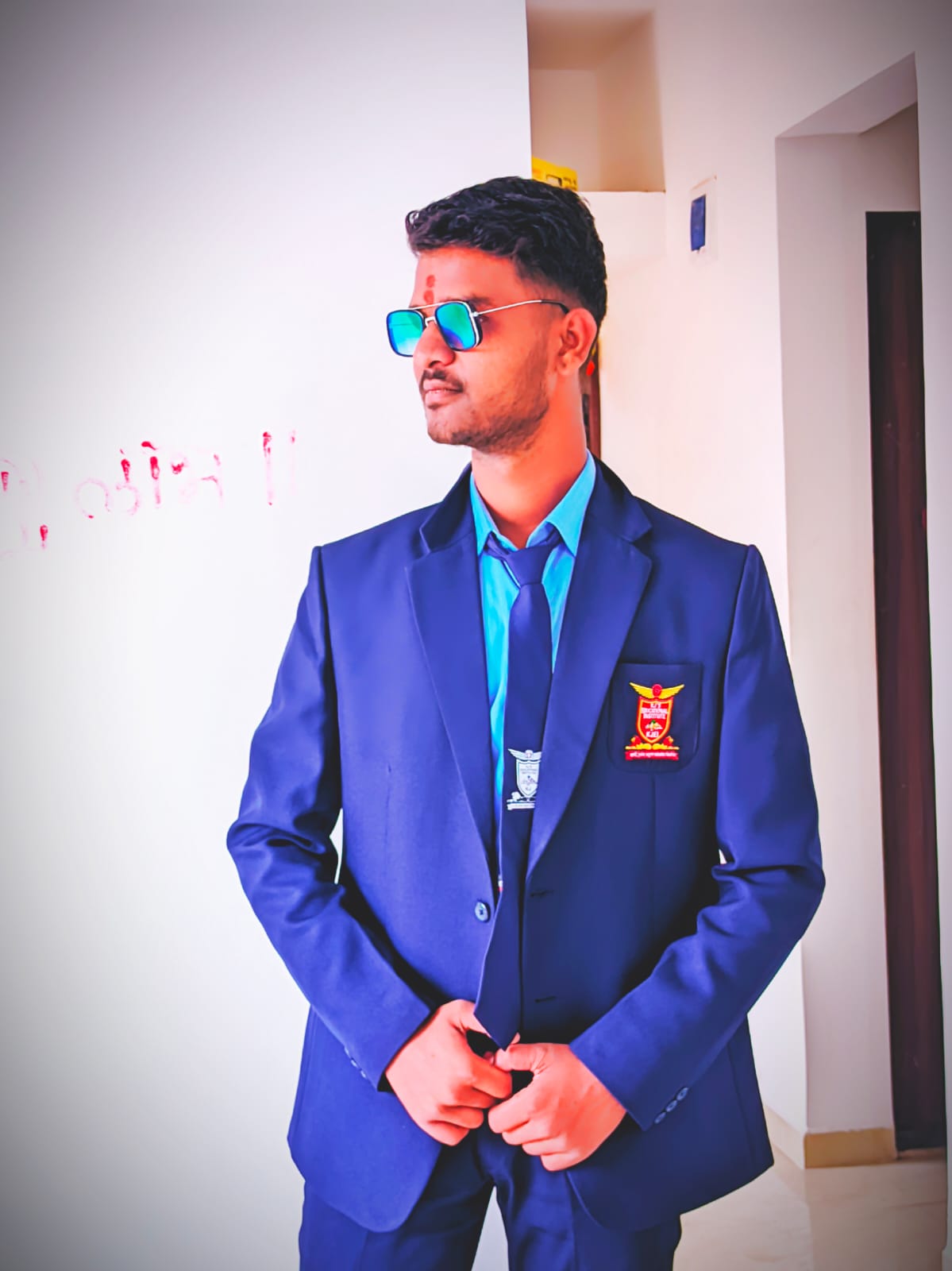 Professional portrait of smiling individual wearing business casual attire standing against a neutral background